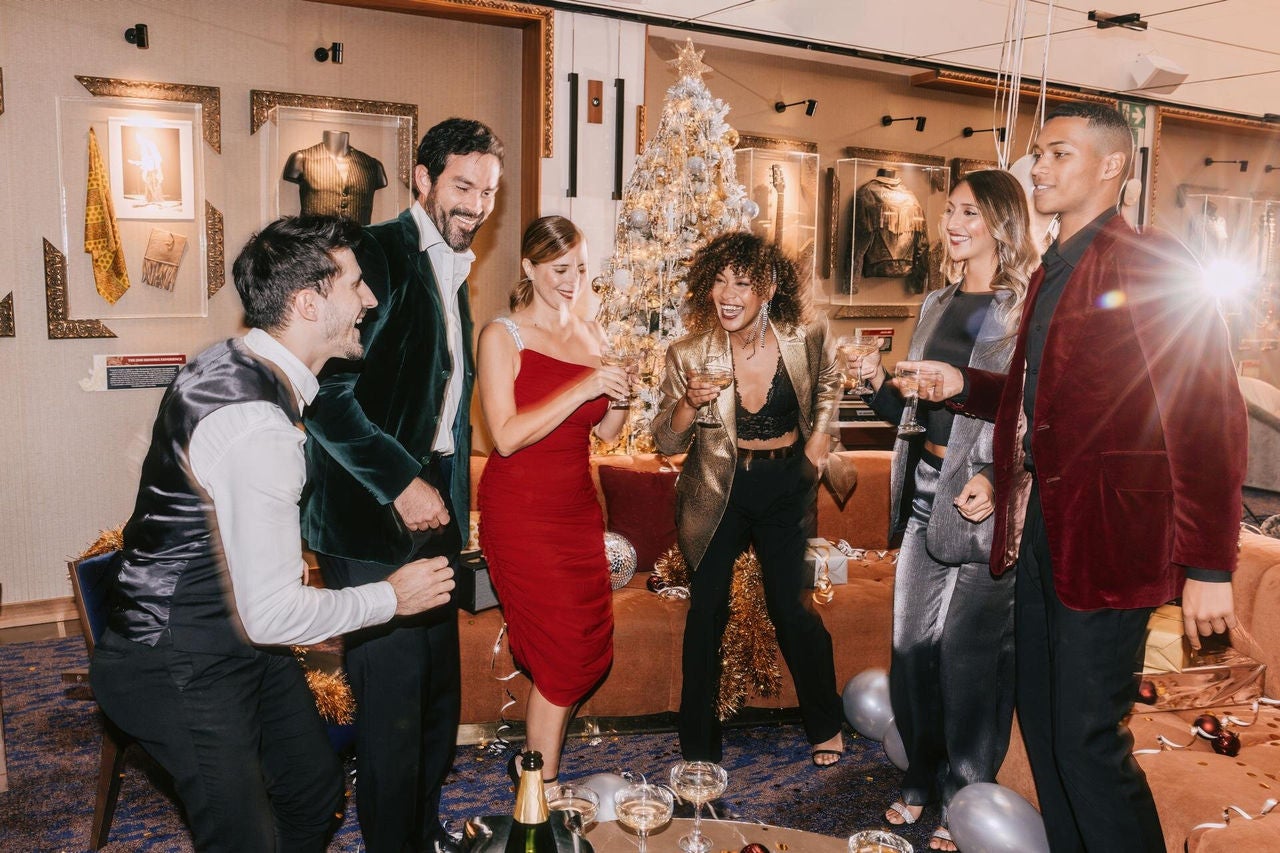 a group of people standing around a christmas tree